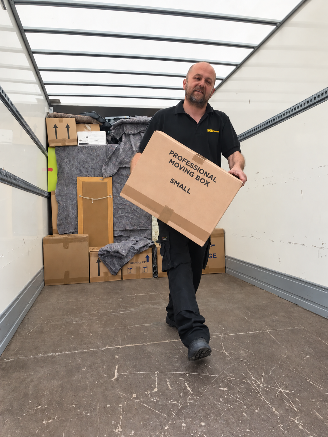 Warpspeed team member carrying a packed box inside a removal van